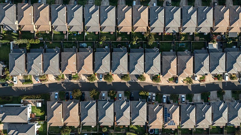 Aerial view of tightly packed houses with streets, driveways and backyards in Sydney.