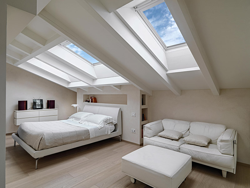 Clean styled bedroom with skylights